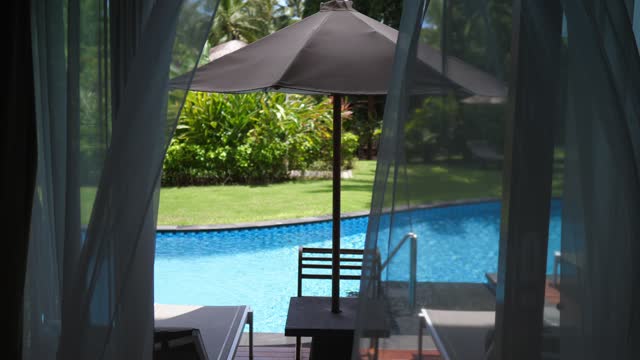 The concept of villas and apartments for holidays and vacations, for tourists from other countries and continents. View from the bedroom window to the private pool.