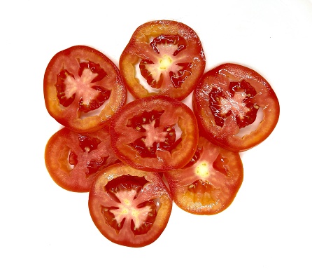 Several sliced ​​tomatoes laying on white background