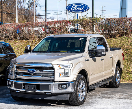Monroeville, Pennsylvania, USA November 24, 2022 A used tan Ford F150 pickup truck for sale at a dealership on a sunny fall day