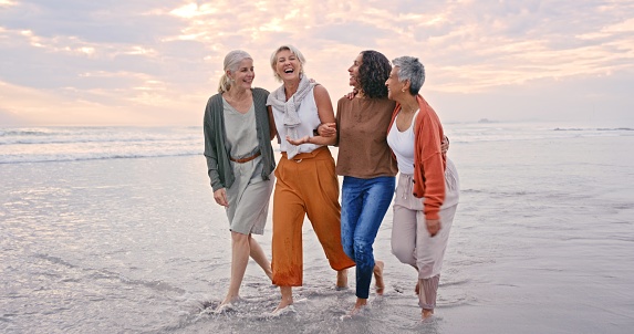 Beach holiday, laughing and senior friends walking in the water during retirement travel in Bali. Summer, smile and diversity with happy elderly women on a walk during group vacation by the ocean