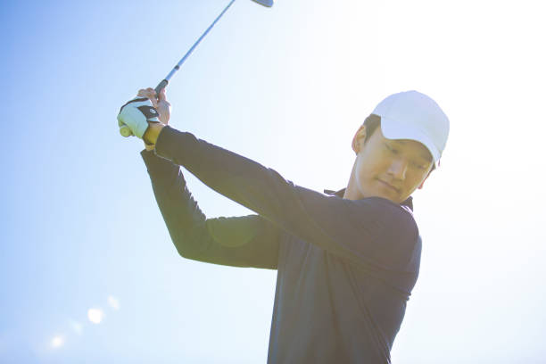 istock Young East Asian man practicing golf on a sunny daytime golf course - stock photo 1444320679