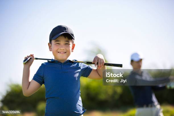 Young East Asian Boy Practicing Golf On A Sunny Daytime Golf Course Carrying A Golf Club On Shoulders Stock Photo Stock Photo - Download Image Now