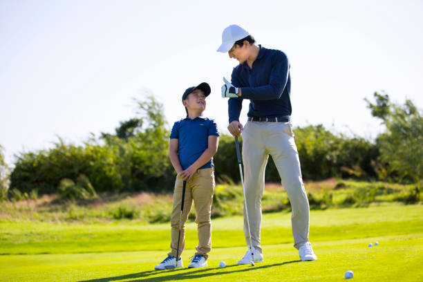 istock Father and son practicing golf tee shots on a sunny golf course, coach and student, encouragement and praise - stock photo 1444320729