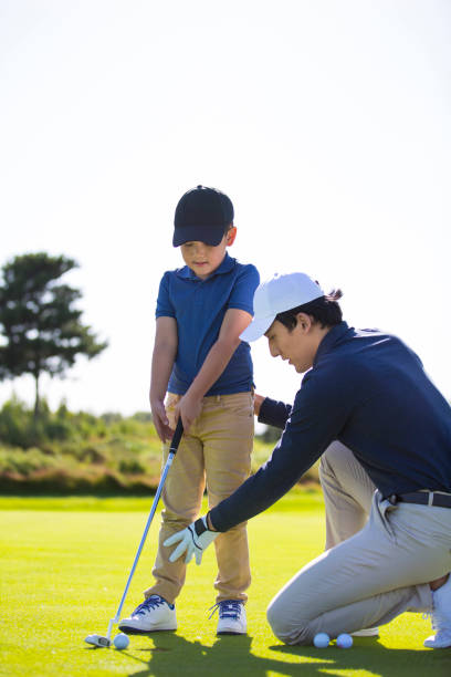 istock Father and son practicing golf tee shots on a sunny golf course, coach and student, encouragement and praise - stock photo 1444320750