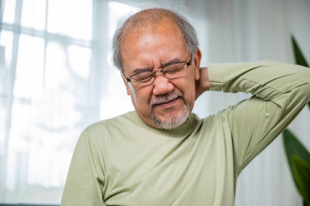istock Old man suffering from nape neck pain at home 1444323178