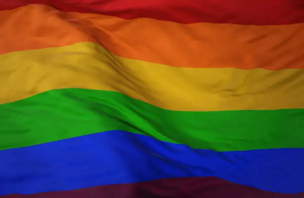 Closeup of a rainbow pride flag waving in the wind.