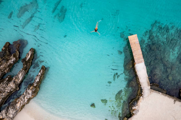 Woman swimming in the Adriatic Sea Vacations on the Albanian Riviera. Top beach destinations in Europe. Snorkelling in a pristine ocean in the Ksamil area. jetty aerial stock pictures, royalty-free photos & images