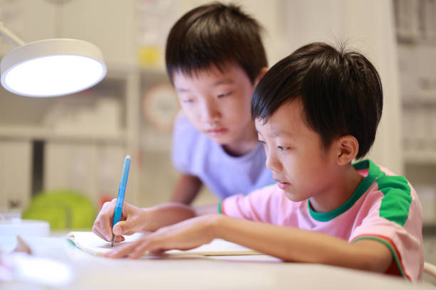 kleine junge malen und schreiben - reading and writing little boys reading asian ethnicity stock-fotos und bilder