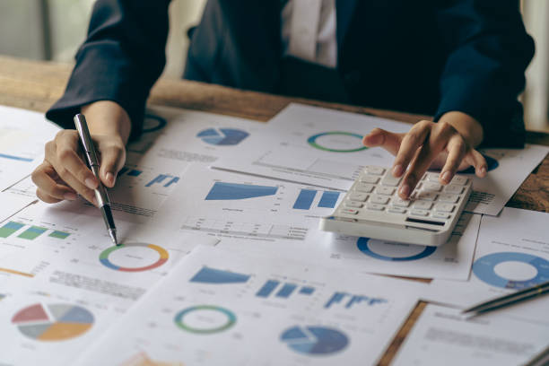 istock Young businessman working at office with financial documents, laptop, calculator on table Planning to analyze financial reports business plan investment accounting concept 1444333366