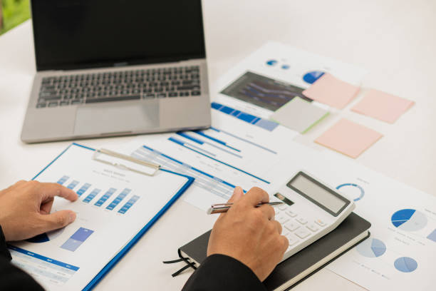 istock Young businessman working at office with financial documents, laptop, calculator on table Planning to analyze financial reports business plan investment accounting concept 1444334014