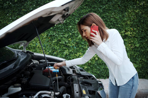 Woman using mobile phone calling for assistance after a car breakdown on street. Woman using mobile phone calling for assistance after a car breakdown on street. engine failure stock pictures, royalty-free photos & images
