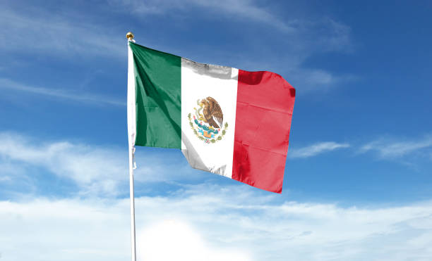 istock Mexican flag in cloudy sky. Waving in the sky 1444339251