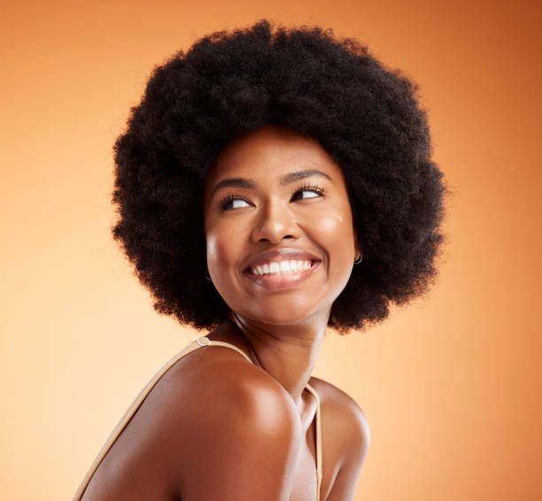 Black woman, african beauty and skincare health of luxury spa model with a smile on an orange studio background. Natural skin, healthy face and happy casual organic cosmetic afro hair treatment model Black woman, african beauty and skincare health of fashion model with a smile on an orange studio background. Natural, healthy skin and happy casual organic cosmetic afro hair treatment fashion model natural hair stock pictures, royalty-free photos & images