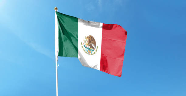 istock Mexican flag in cloudy sky. Waving in the sky 1444339635