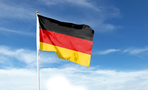 istock German flag in cloudy sky. Waving in the sky 1444340279