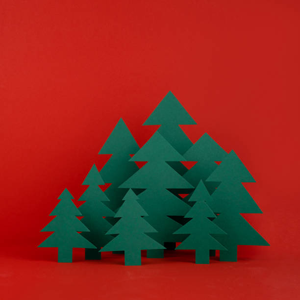 istock Bright Christmas background - paper green spruce forest on red backdrop in minimalist modern style, copy space, square. New year scene for presentation products, advertising text, card, poster, flyer. 1444347859