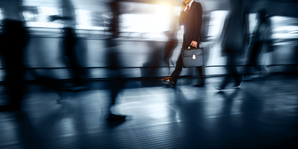 Blurred businessman walking and talking on mobile phone