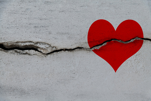 Red heart on a cracked wall