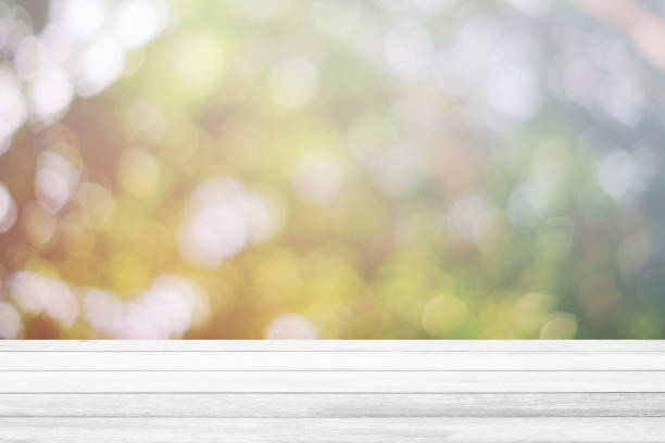 istock White Wooden Table with Nature Bokeh and Light Leak, Suitable for Background, Backdrop, and Mock up. 1444350687
