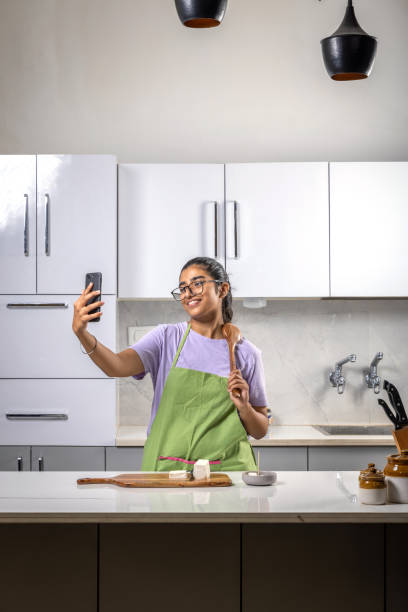 istock An young girl taking a selfie while chopping a paneer in a kitchen 1444351982