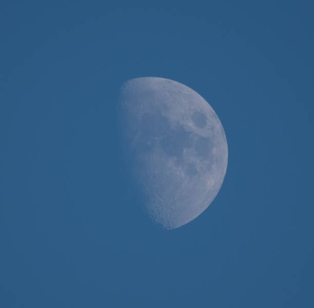 istock Close up of half moon during daylight with blue sky background 1444357115