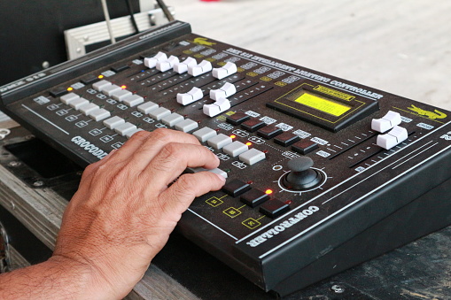Bandung, November 21, 2022 : Hand of a person using a control sound mixer, mixing equipment for a concert, electronic device.
