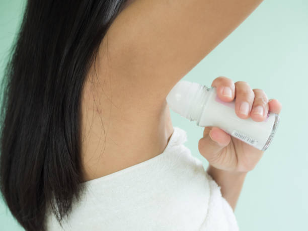 Woman Applying Deodorant Roll On Under Armpit After Shower