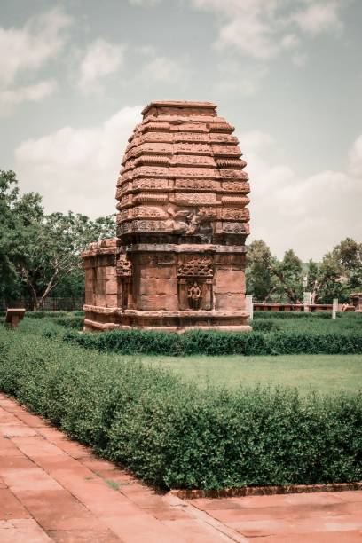 istock Vertical shot of a structure in Pattadakal surrounded by hedges with a cloudy sky in the background 1444361237