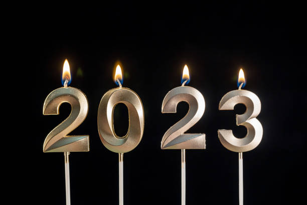 accensione di una candela digitale "2023" - image created 21st century still life horizontal close up foto e immagini stock