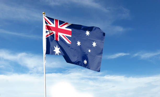 istock Australian flag in cloudy sky. Waving in the Sky 1444362924