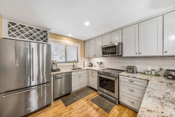 istock Contemporary kitchen with white cupboards and wooden floor 1444363159