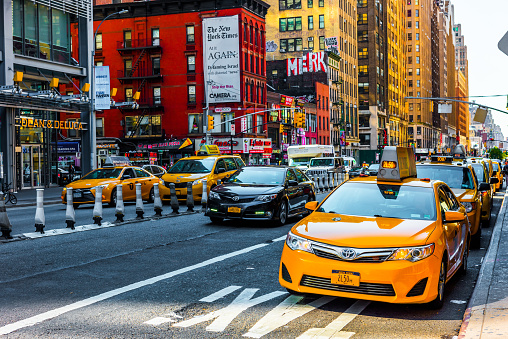 Crowded Times Square full of people and driving yellow cabs. Long exposure. Manhattan, New York City, USA.