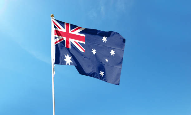 istock Australian flag in cloudy sky. Waving in the Sky 1444365103