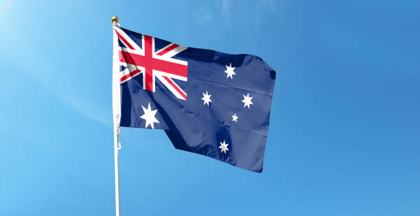 istock Australian flag in cloudy sky. Waving in the Sky 1444365254
