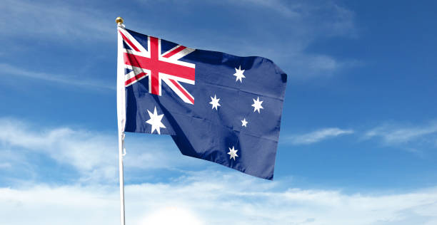istock Australian flag in cloudy sky. Waving in the Sky 1444365263