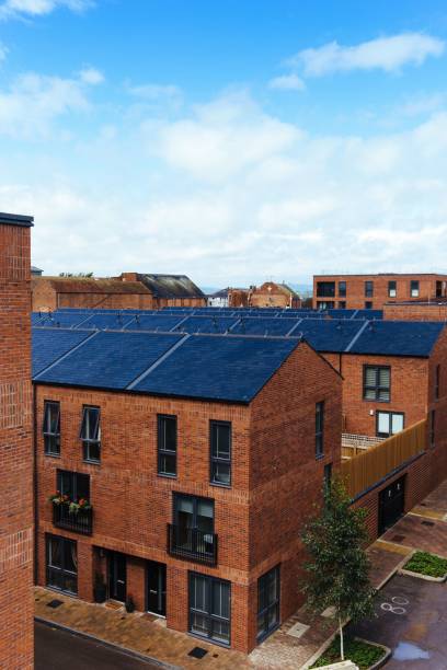 istock Vertical of red brick buildings under a blue sky with clouds. 1444368711