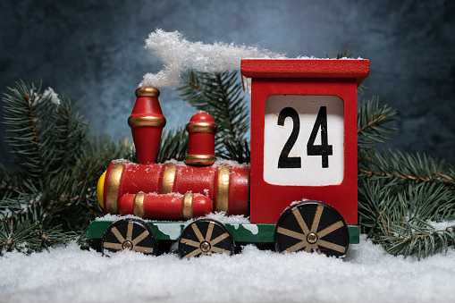 Wooden train Christmas advent calendar. Countdown to Christmas festive decoration. Counting down the days until Christmas wood number blocks. Composition with tree branches and white snow.