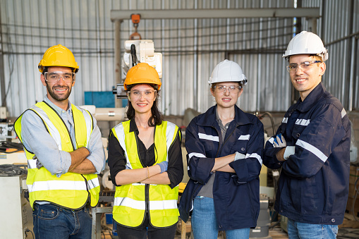 Portrait of group of male and female ethnic diverse engineer worker wear safety uniform, glasses and helmet working  in the industry factory