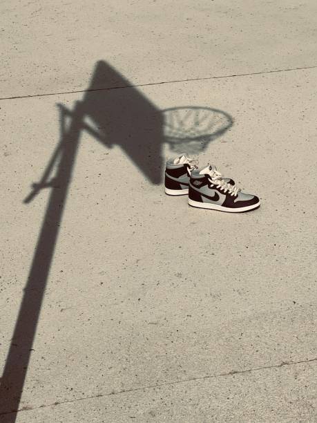 Vertical shot of bright Nike air Jordan one 85 highs sneakers on basketball court Ormond beach, United States – July 05, 2022: A vertical shot of bright Nike air Jordan one 85 highs sneakers on basketball court nike air photos stock pictures, royalty-free photos & images