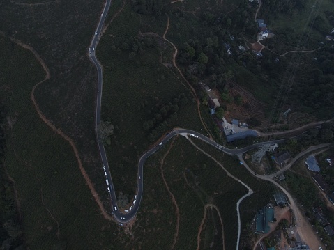 An aerial view of a curvy road passing through green tea plantations in Munnar, India