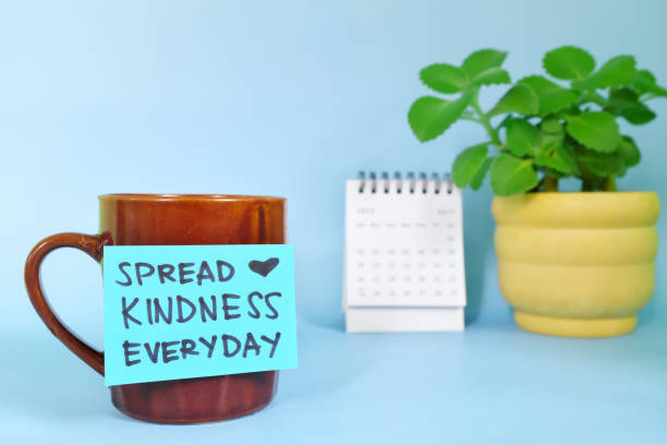 Spread kindness everyday and share blessings motivation and inspiration concept. Selective focus of a cup of coffee with handwritten bright paper note.
