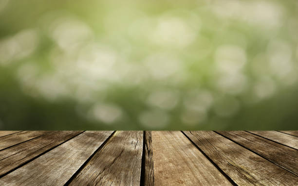 istock Wooden table top on green bokeh background. 1444383215