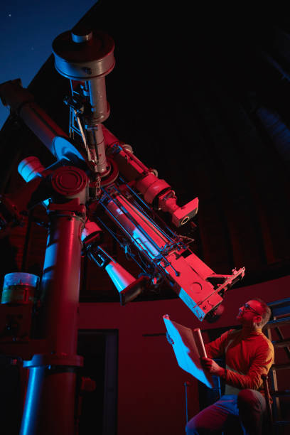 istock Astronomer with a big astronomical telescope in observatory doing science research of space and celestial objects. 1444383987