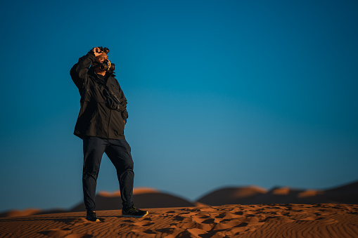 Asian Chinese man with  steampunk mask in Sahara Desert