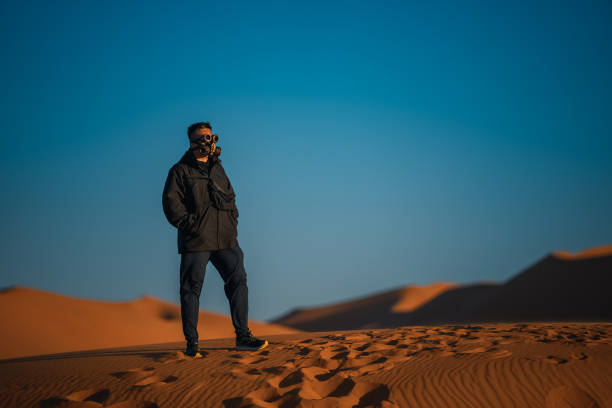 istock Asian Chinese man with  steampunk mask in Sahara Desert 1444384066
