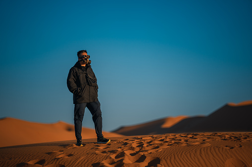 Asian Chinese man with  steampunk mask in Sahara Desert