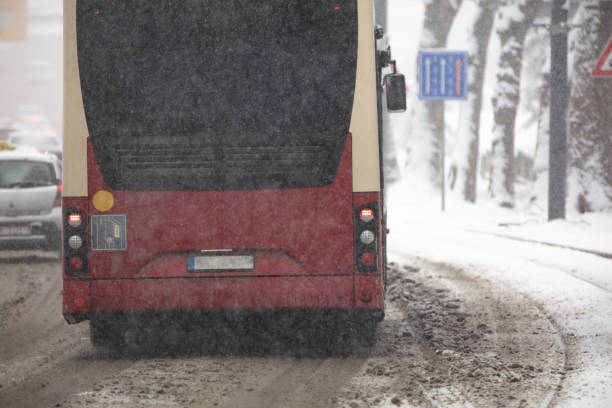 transporte público en autobús que conduce por calles nevadas en condiciones invernales. - public transportation winter bus front view fotografías e imágenes de stock