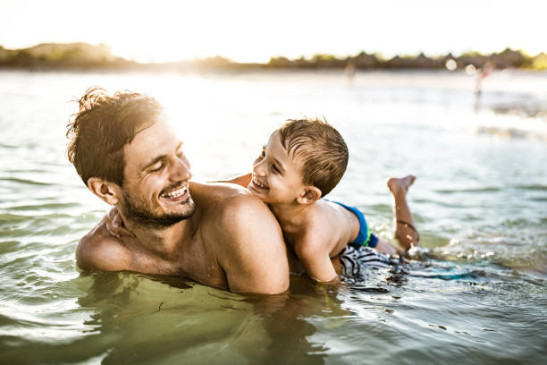 istock Happy single father and son having fun in summer day at sea. 1444384812
