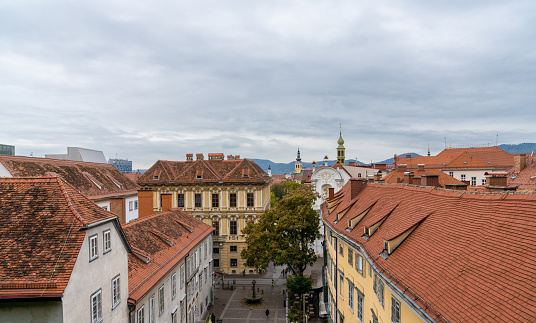 Graz, Austria - 9 October, 2022: view of the rooftops of the old centre of Graz with the Schlossberg Square below