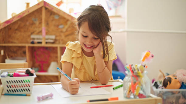 istock Little girl drawing while sitting at the table in her room 1444387986